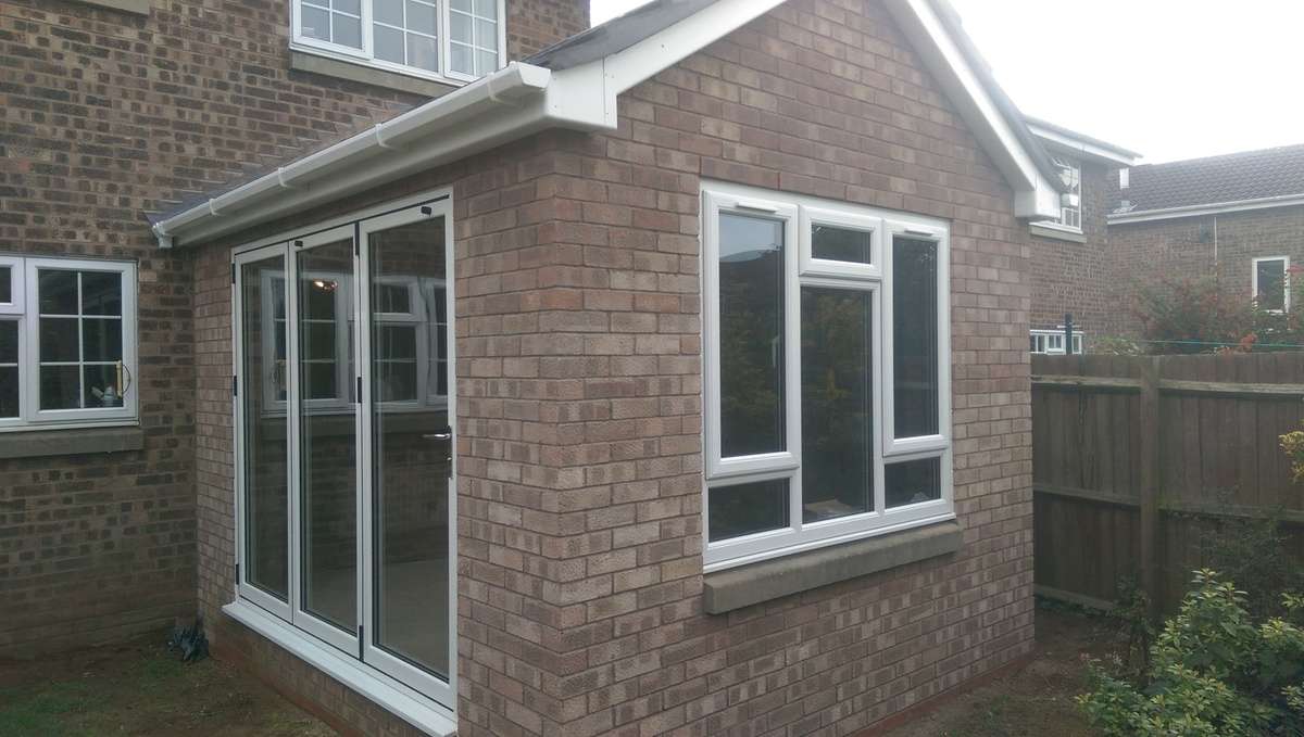 Outdoor view of rear dinning room extension with vaulted ceiling and bifold doors